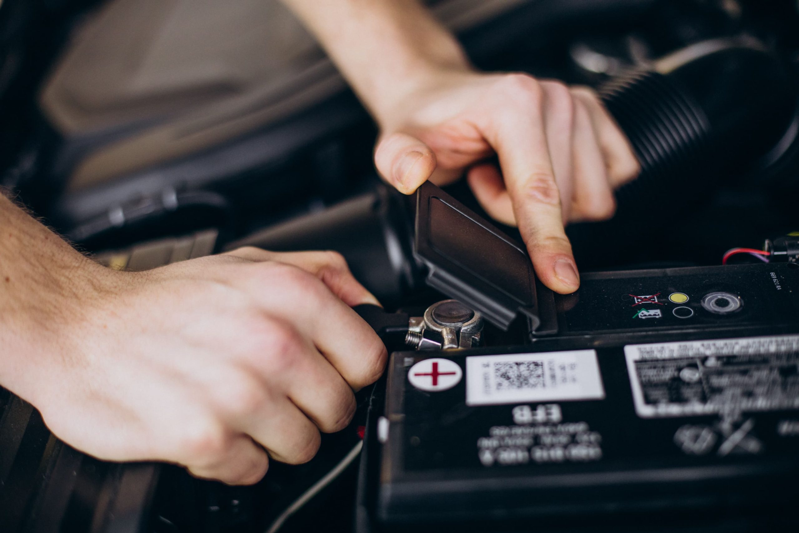 Pemeriksaan Tanda Aki Mobil Bekas Mau Soak Inspektor mengukur tegangan dan daya tahan aki menggunakan battery tester untuk melacak tanda aki mobil bekas mau soak